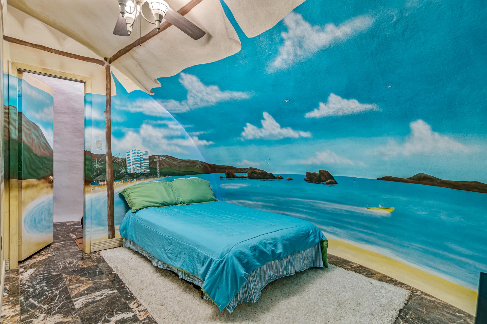 The second bedroom is painted to feel like a tropical cabana.