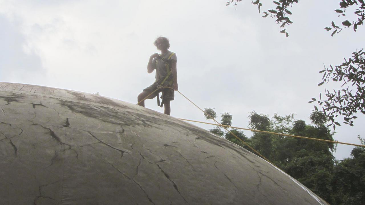 Ben Erwin climbing on top of his dome home.