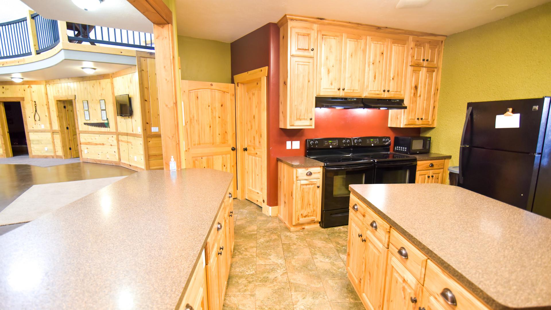 Two ranges and two refrigerators in the large kitchen.