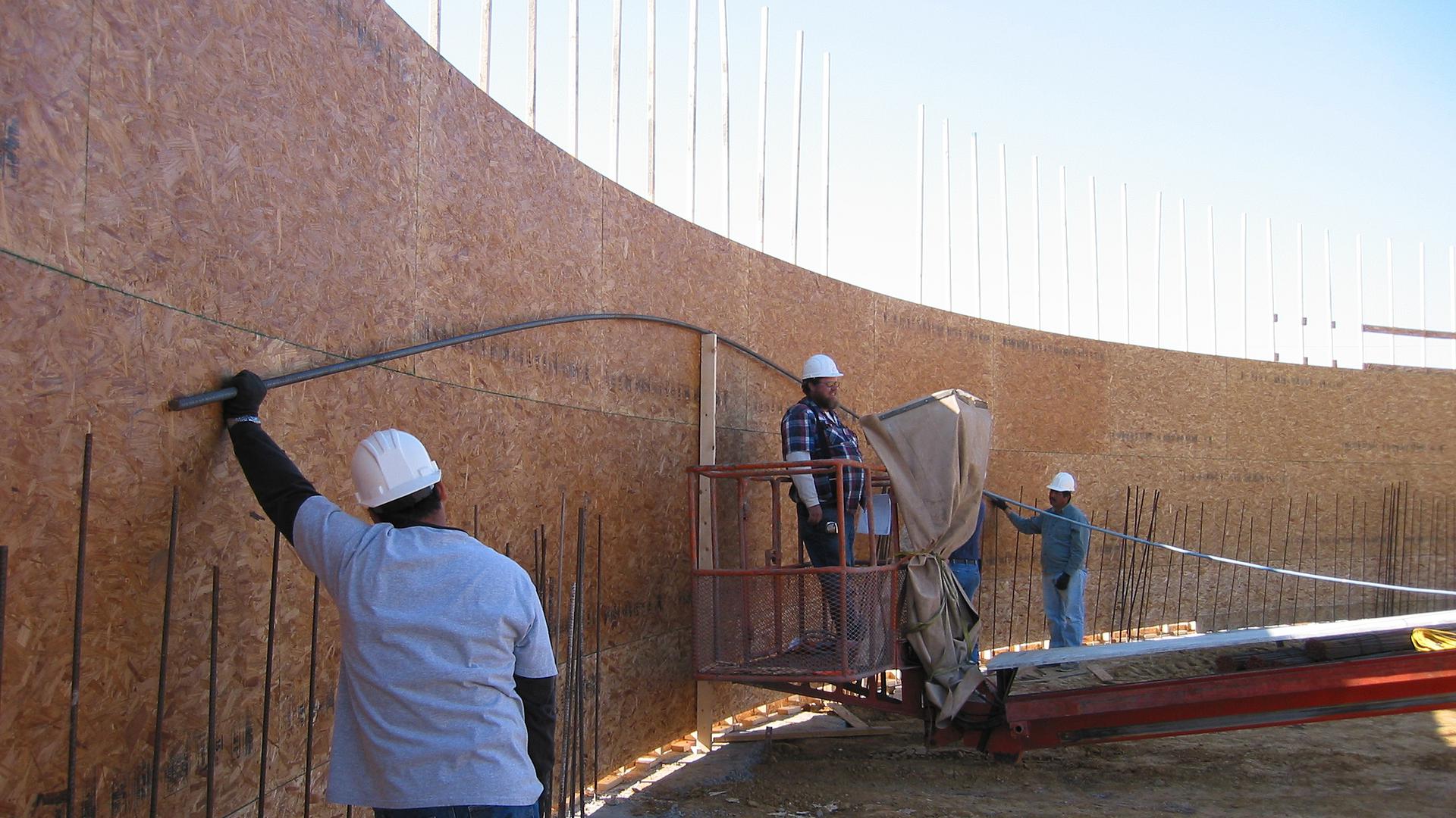Workers attaching rebar to the plywood form.