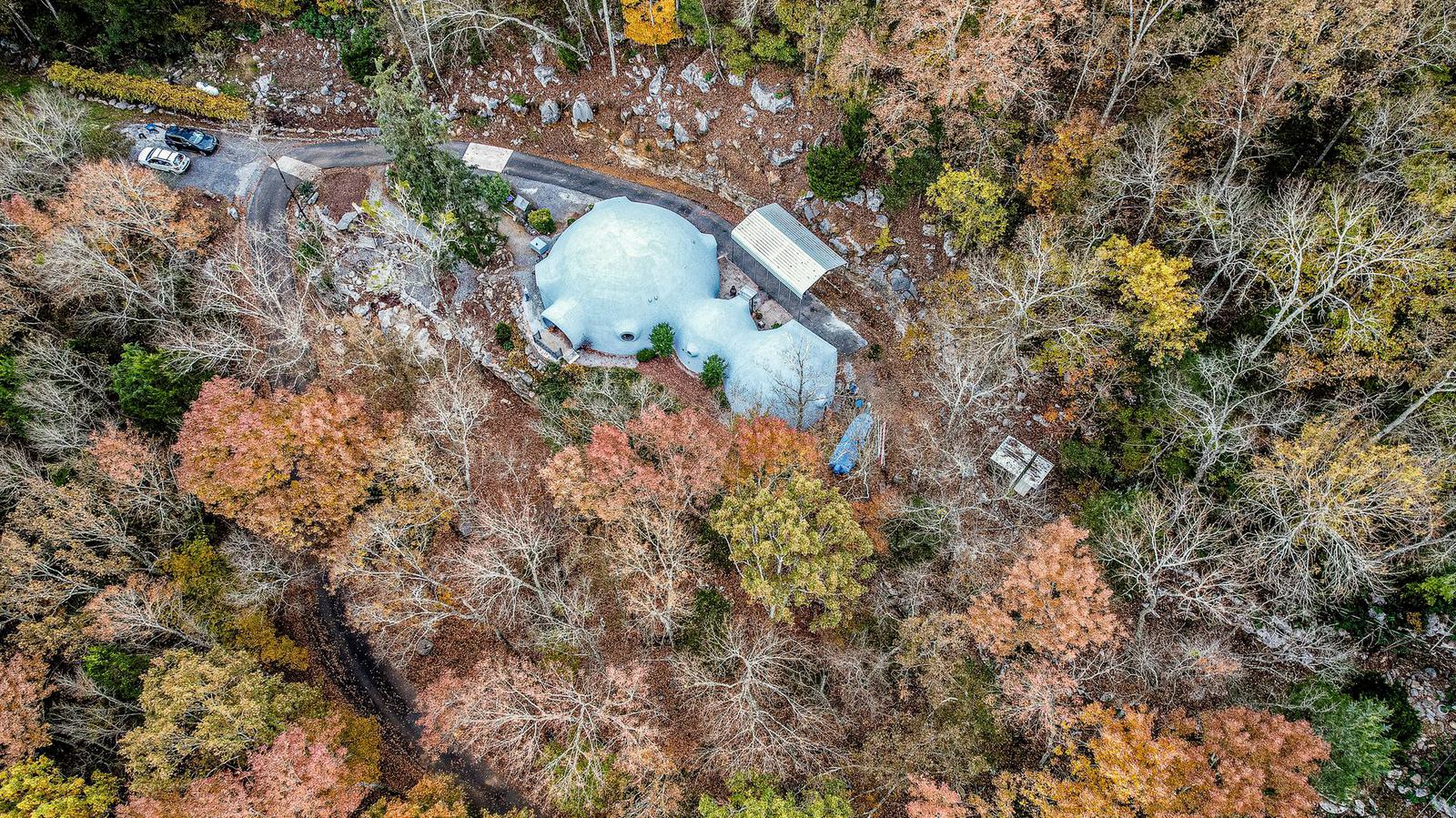 An aerial view of the tri-dome home among the trees.