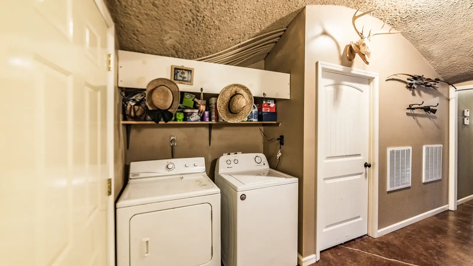 The washing machine and dryer are next to the HVAC room.