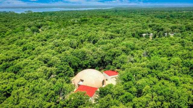 Aerial view of the dome home among the trees.