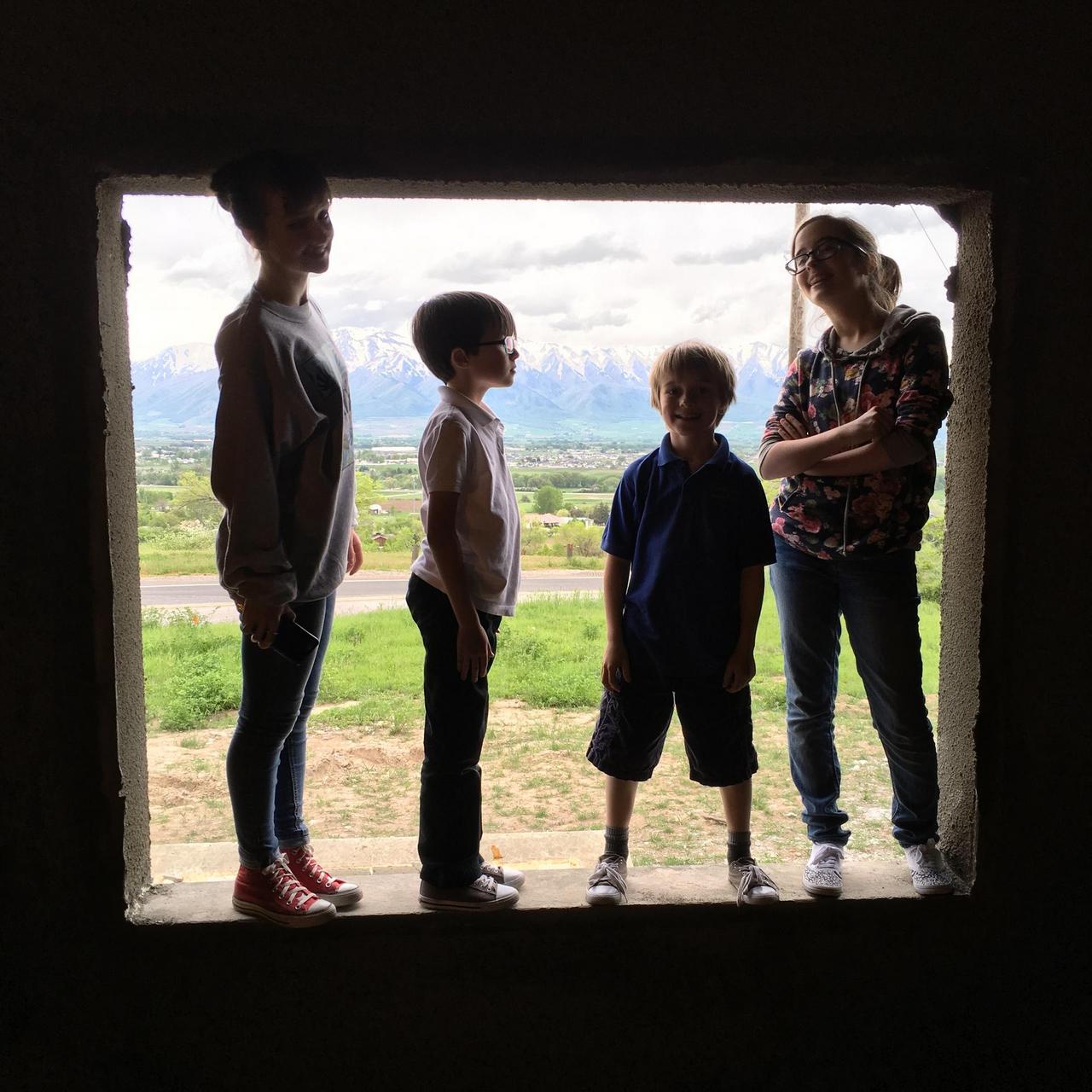 The four South children standing in a window opening.