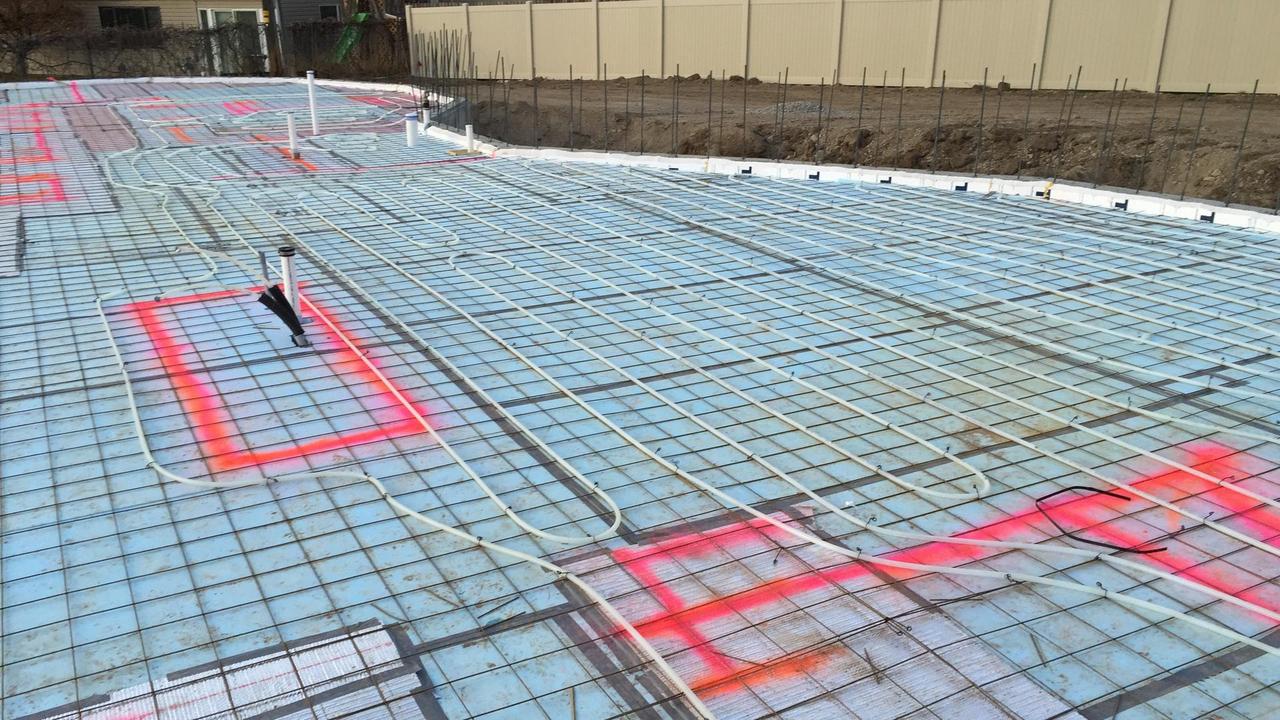 Radiant heat water lines are laid over insulation foam boards.
