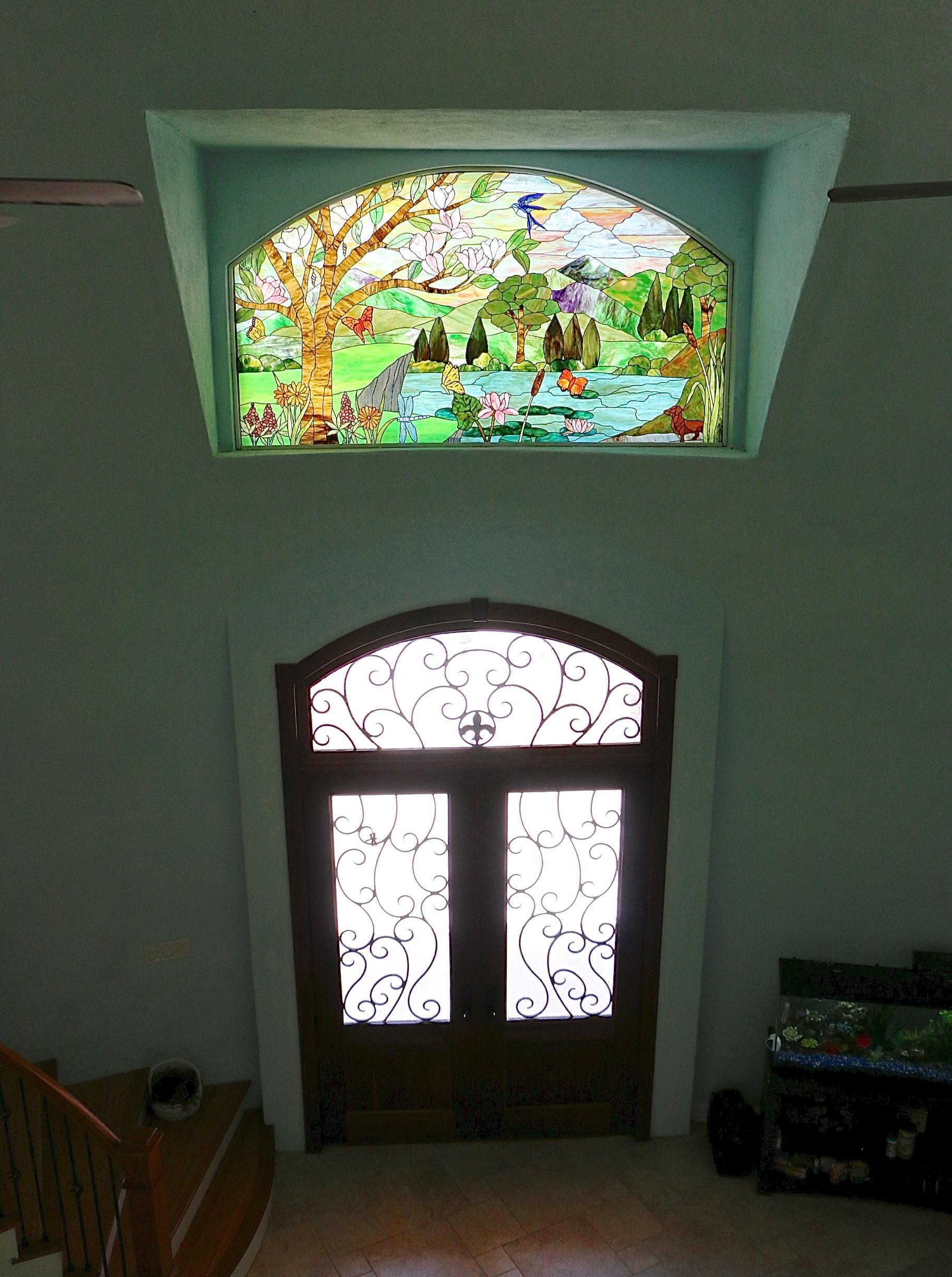 Stained glass window above main entrance.
