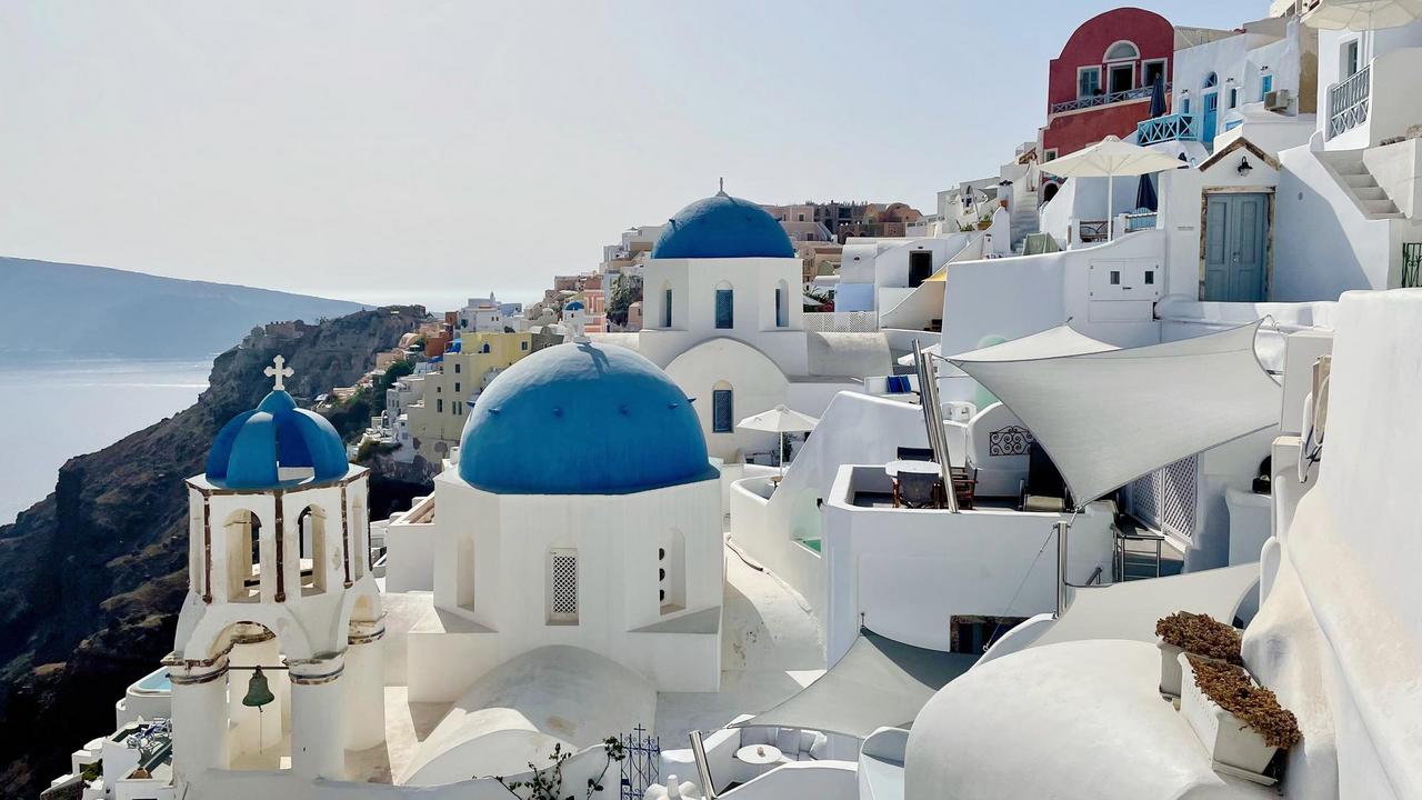 Whitewashed buildings and blue-domed churches in Santorini, Greece.